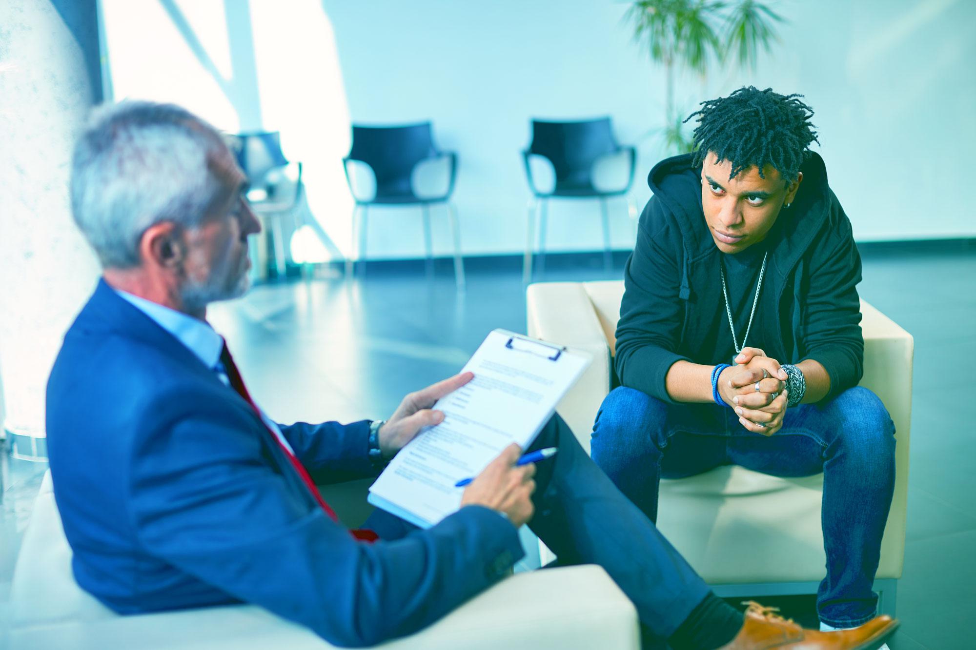 Man with clipboard discussing care with younger man