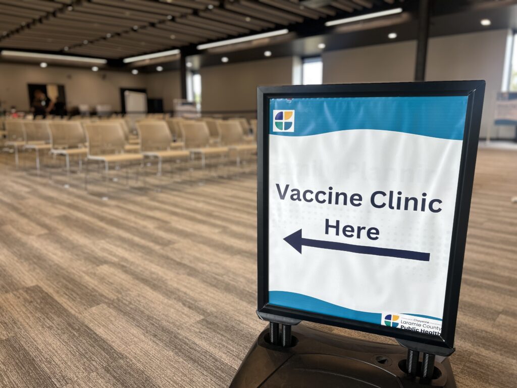photo of a sign that reads vaccine clinic here, with an arrow pointing
